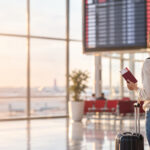 Traveler looking at an airport departures board after missing a flight