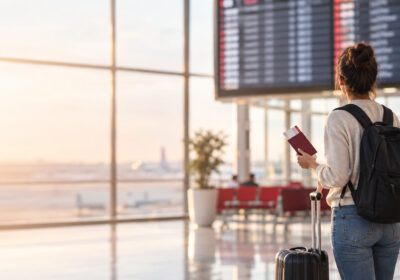 Traveler looking at an airport departures board after missing a flight
